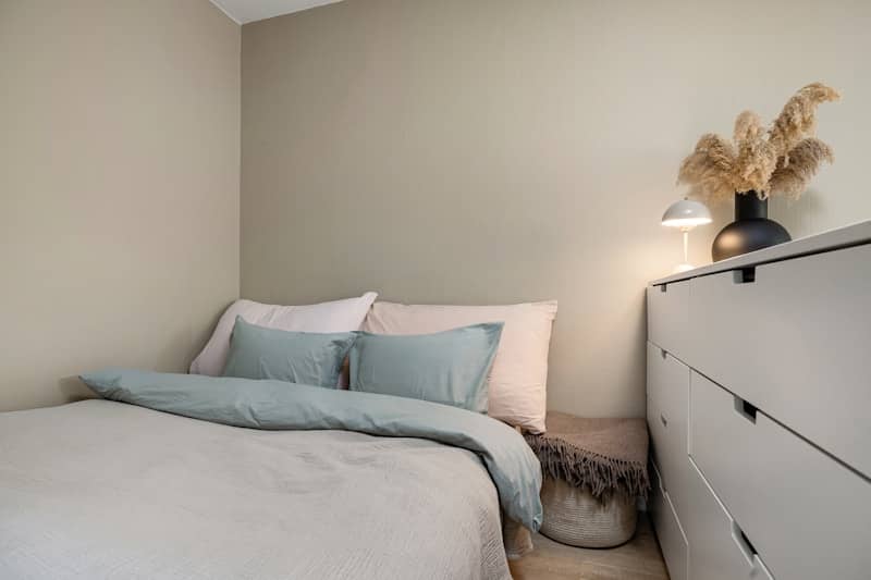 A bedroom with a bed and a dresser