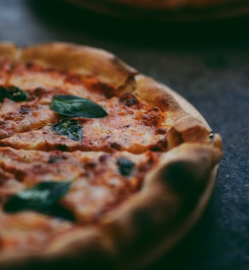 selective focus photography of two pizzas