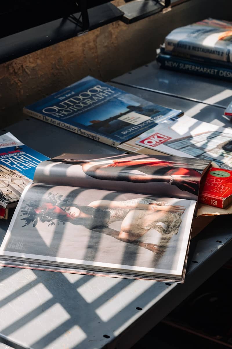 Sunlight casts striped shadows across magazines on a table.