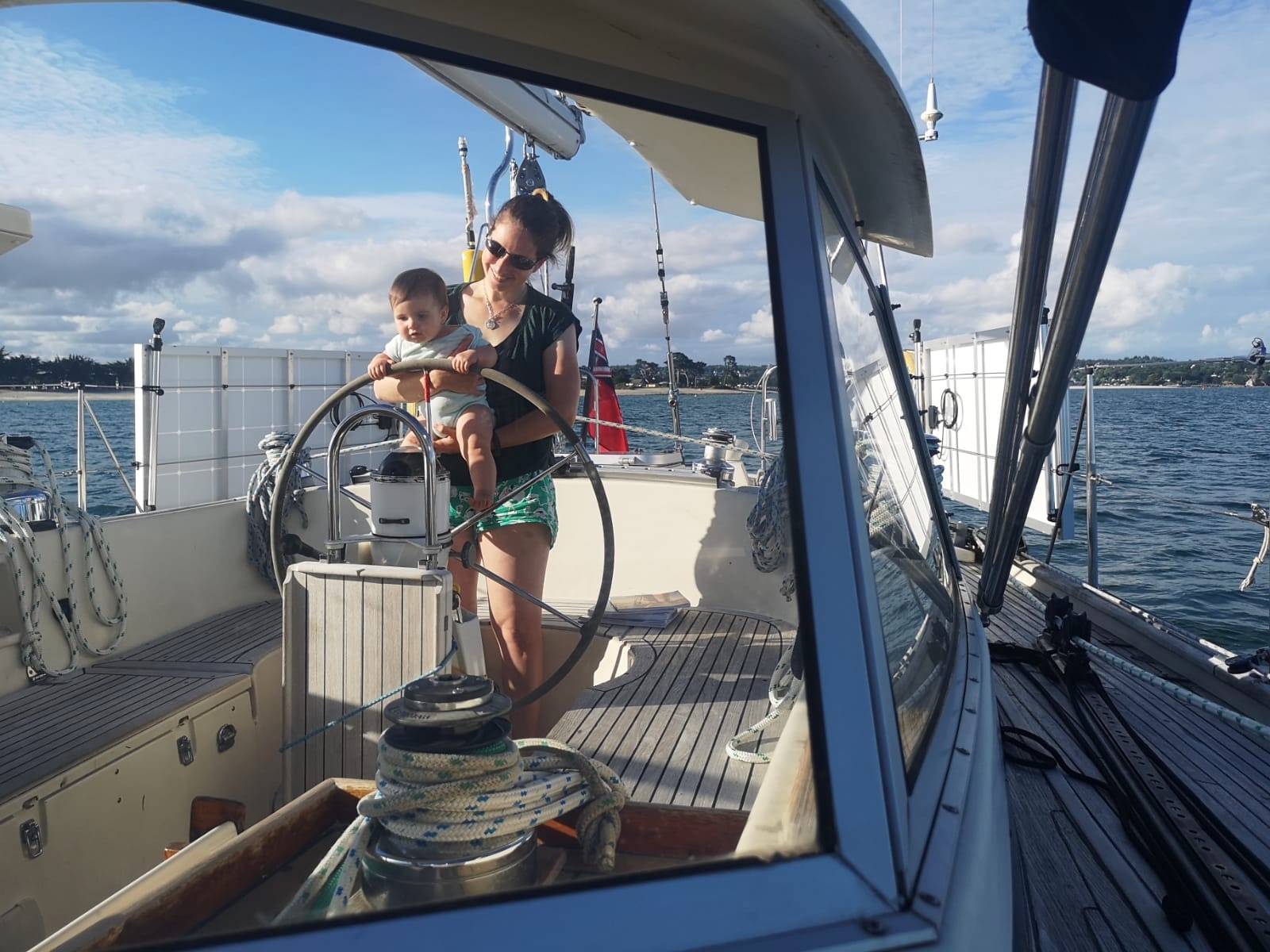 Mother and child at the helm in the cockpit while at anchor