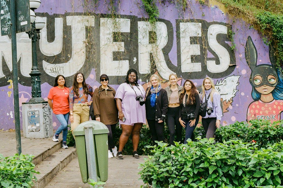 Women standing in front of a Mujeres mural on a Wanderful Creator Campaign in Peru