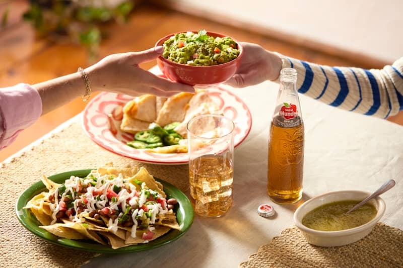 Friends sharing a meal with drinks and mexican food.