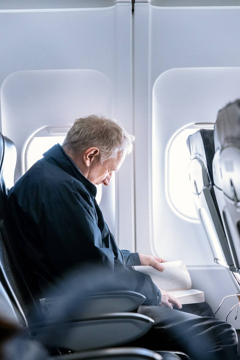 a man reading a book on an airplane