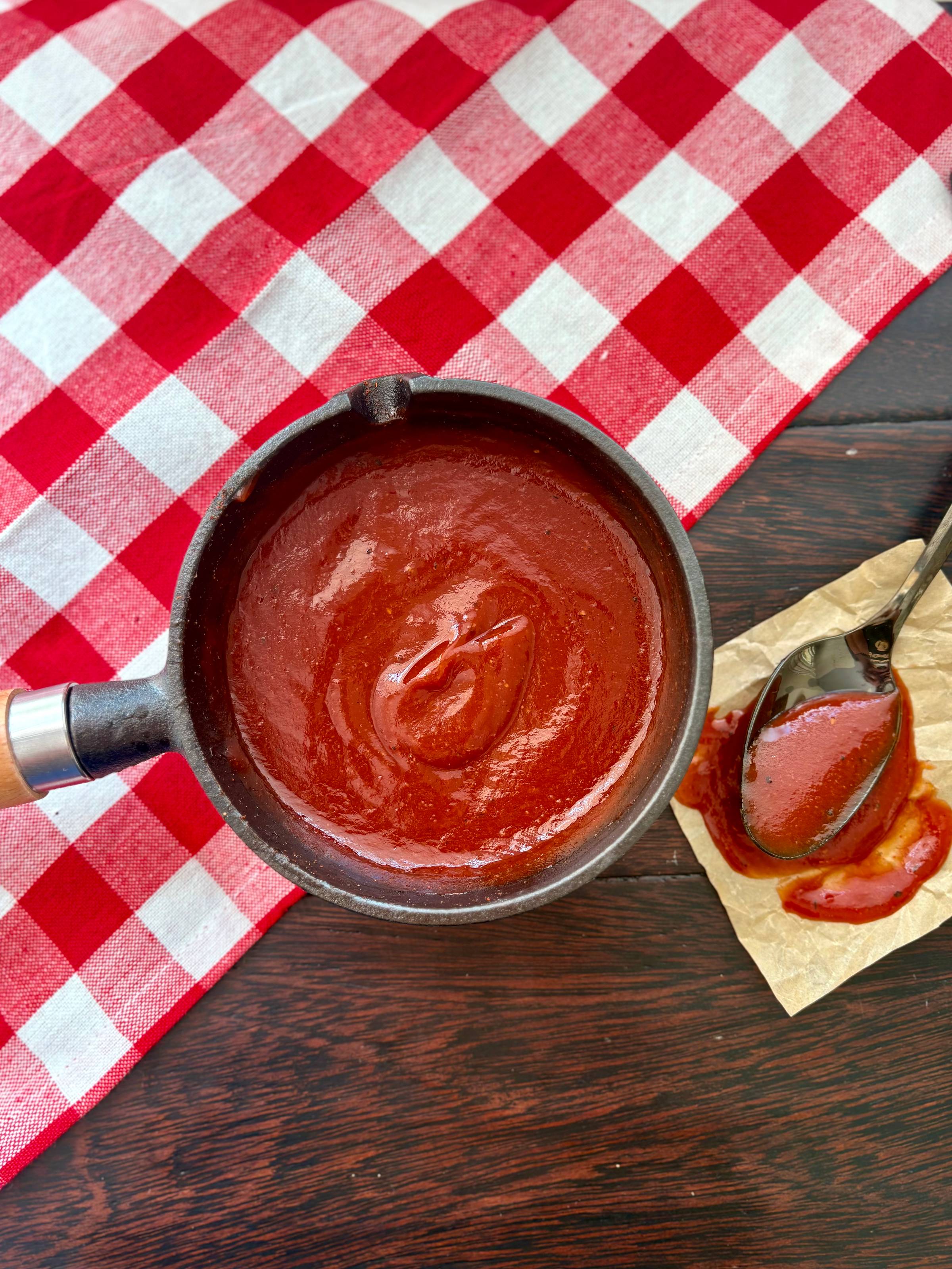 a pot of classic barbecue sauce next to a spoon