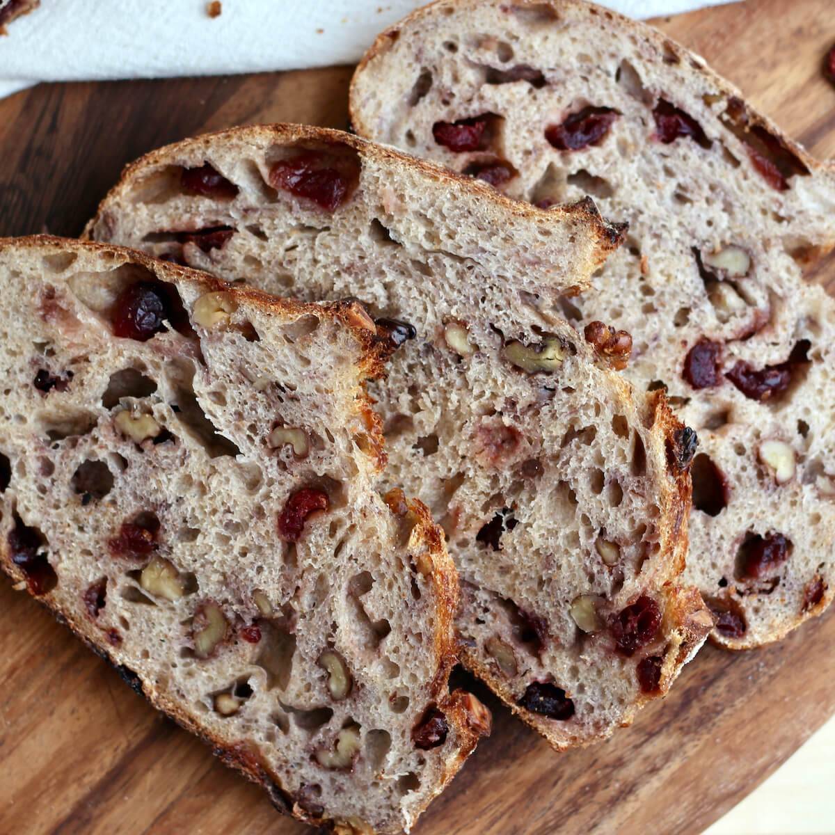 Three slices of cranberry walnut sourdough bread.