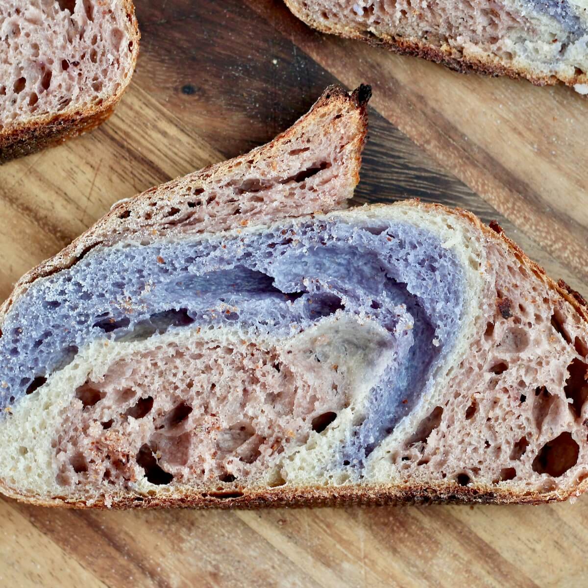 A slice of red, white, and blue sourdough bread on a cutting board.