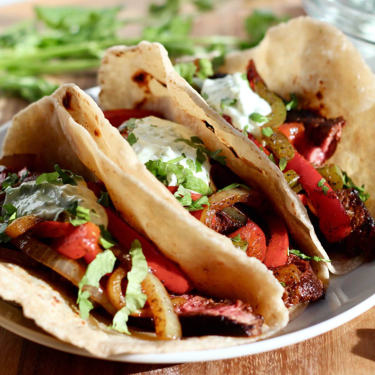 Three steak and pepper tacos made on sourdough discard tortillas.