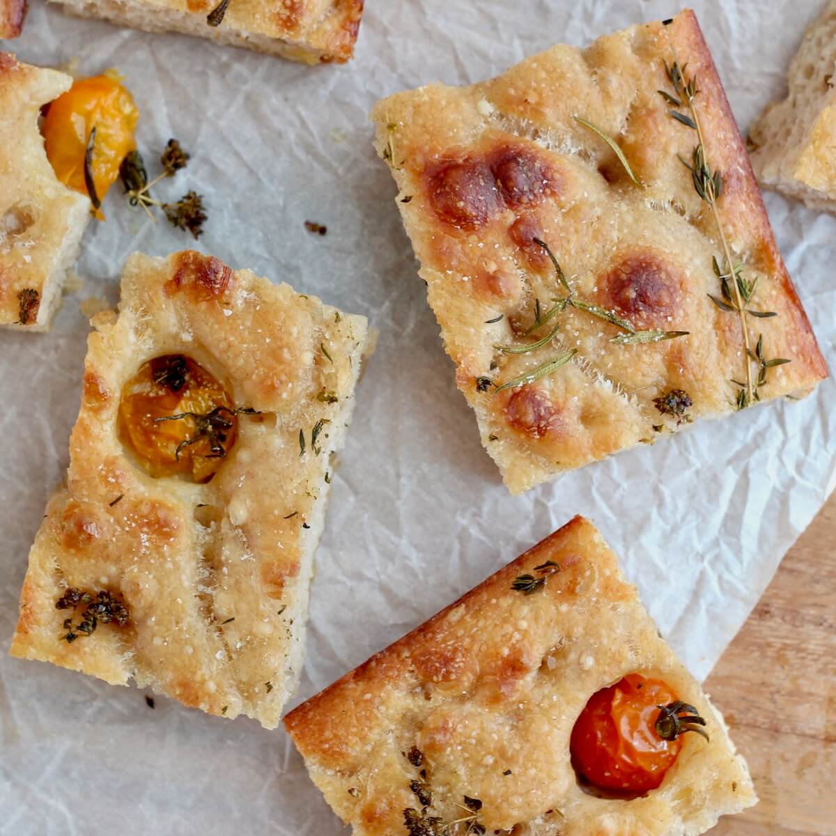 Pieces of sourdough focaccia with tomatoes and herbs.