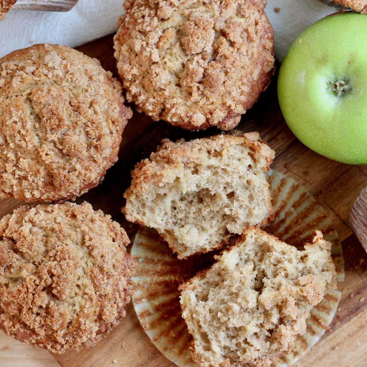 Sourdough apple muffins with cinnamon streusel on a table.