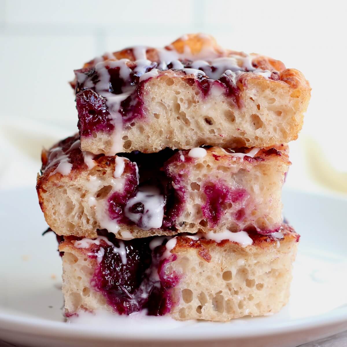 Three pieces of blueberry sourdough focaccia stacked on top of each other.