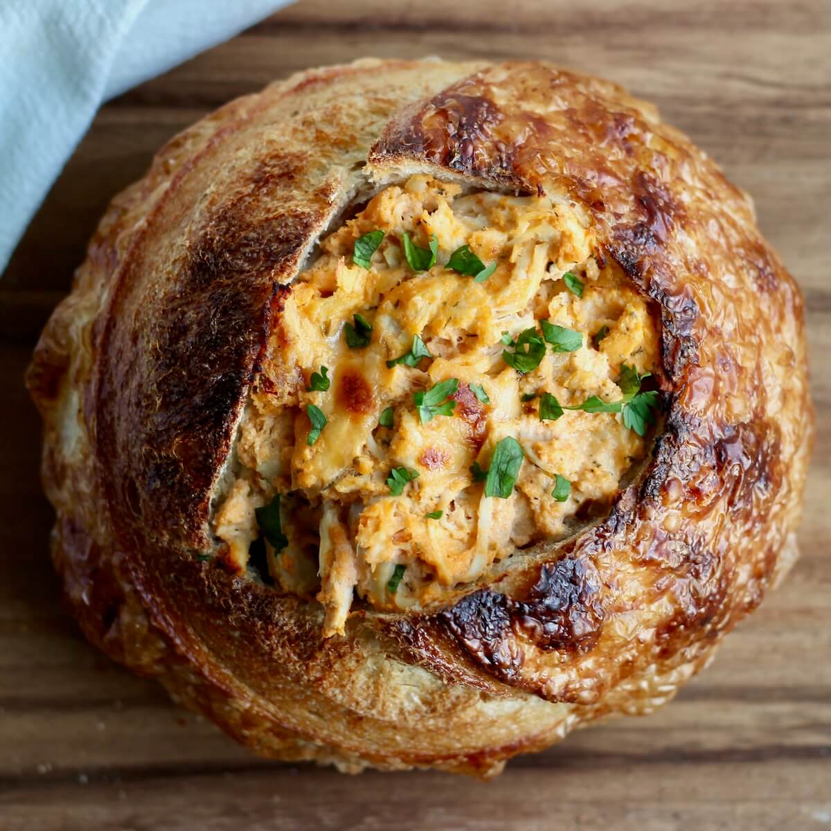 A sourdough bread bowl filled with buffalo chicken dip.