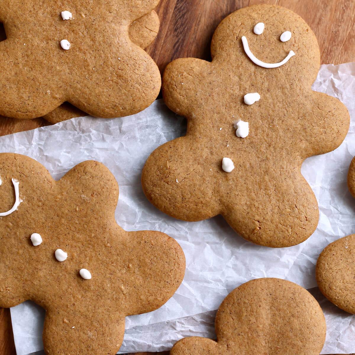 Several sourdough gingerbread men decorated with a smiley face and three buttons.