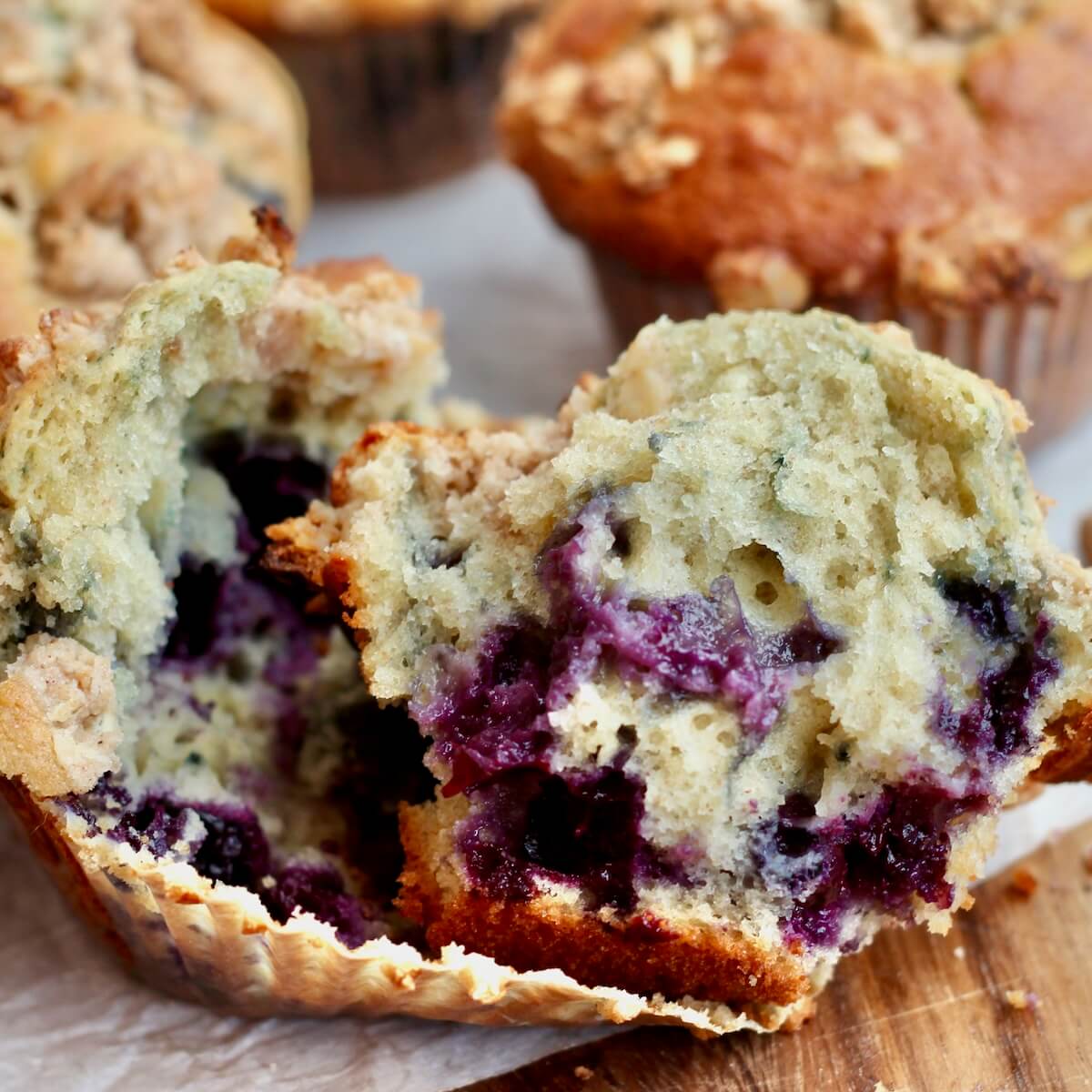 A sourdough blueberry muffin split in half in the wrapper.