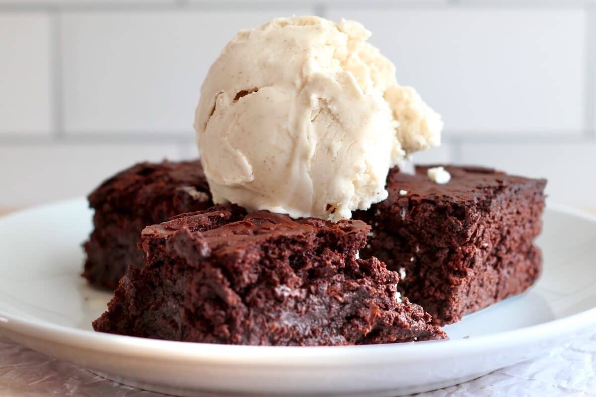 Three sourdough brownies topped with a scoop of sourdough ice cream.