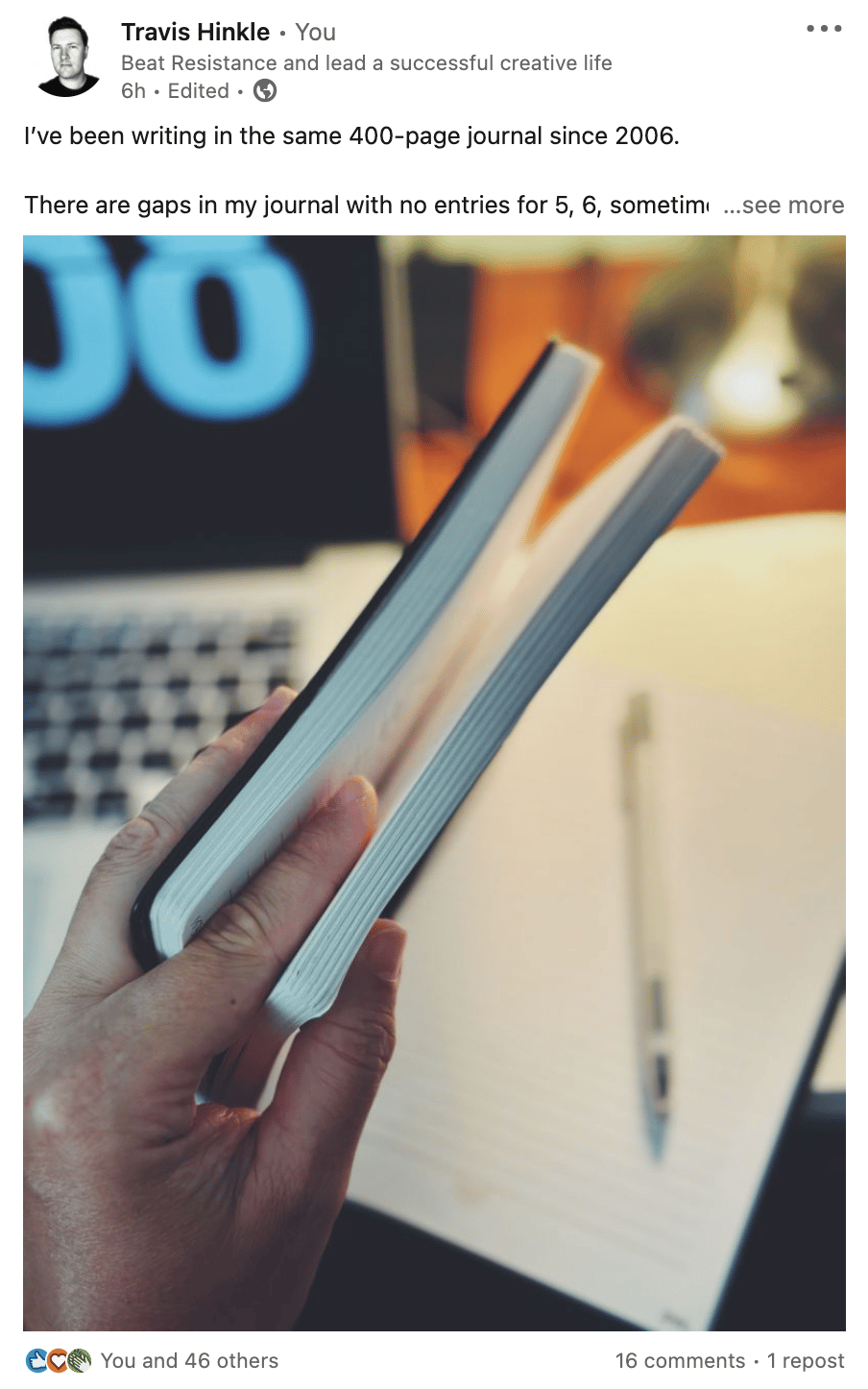 A man holds a journal with his fingers separating the pages between entries over 16 years and the entries from 2023.