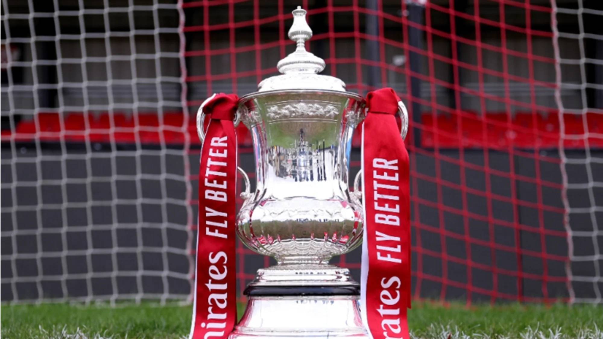 The FA Cup on a football pitch in front of a goal