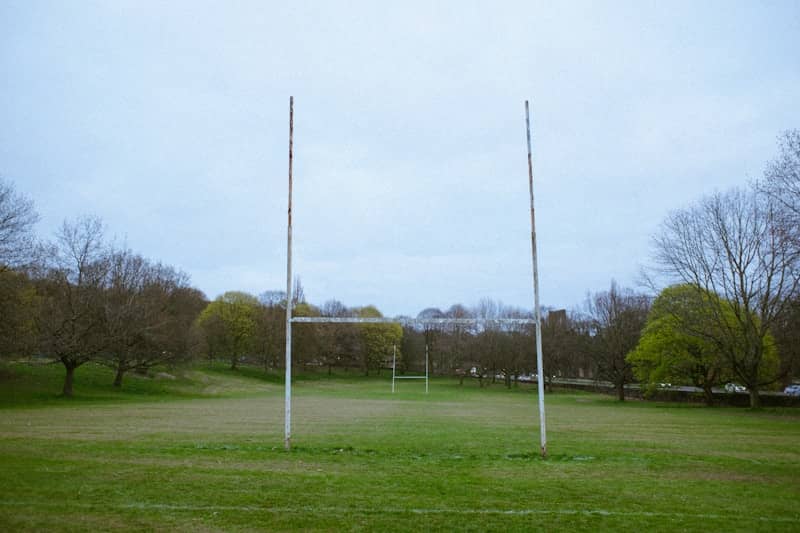 Rugby goal posts stand on a grassy field.