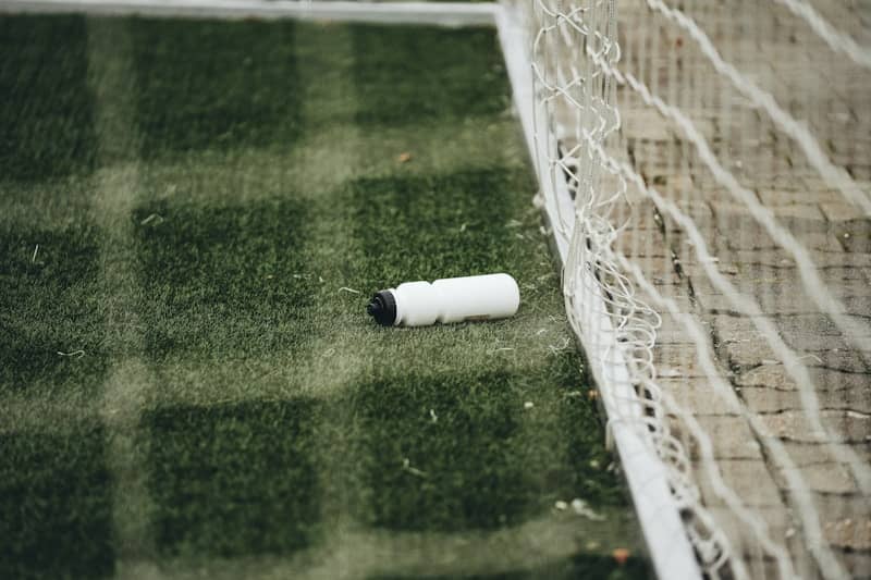 A soccer goal net with a roll of paper on the ground