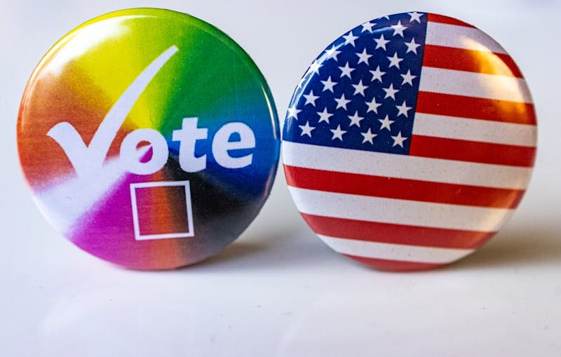 Two buttons with the words vote and the american flag