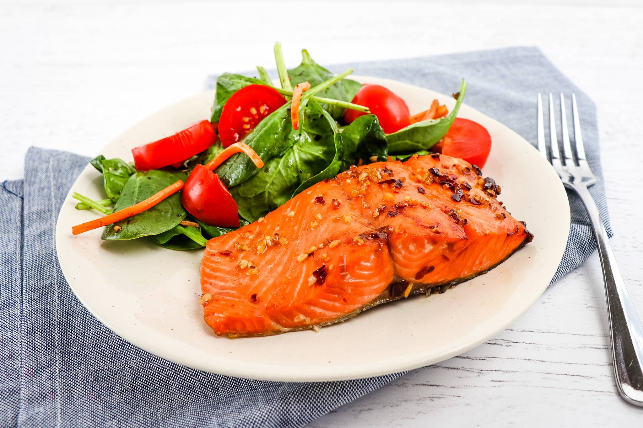 A plate with air fryer maple salmon and a side salad.