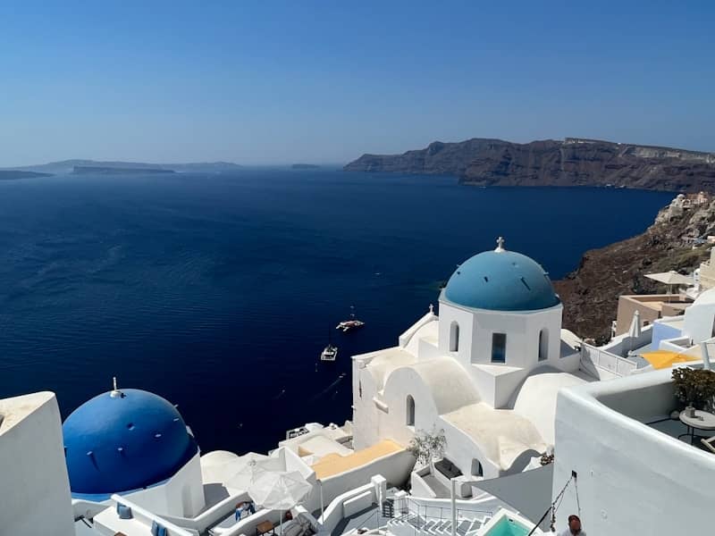 Blue-domed churches overlook the aegean sea in santorini.