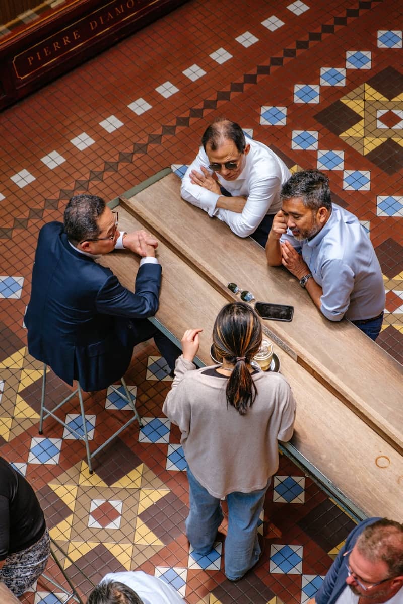 Four people gathered around a long wooden table.