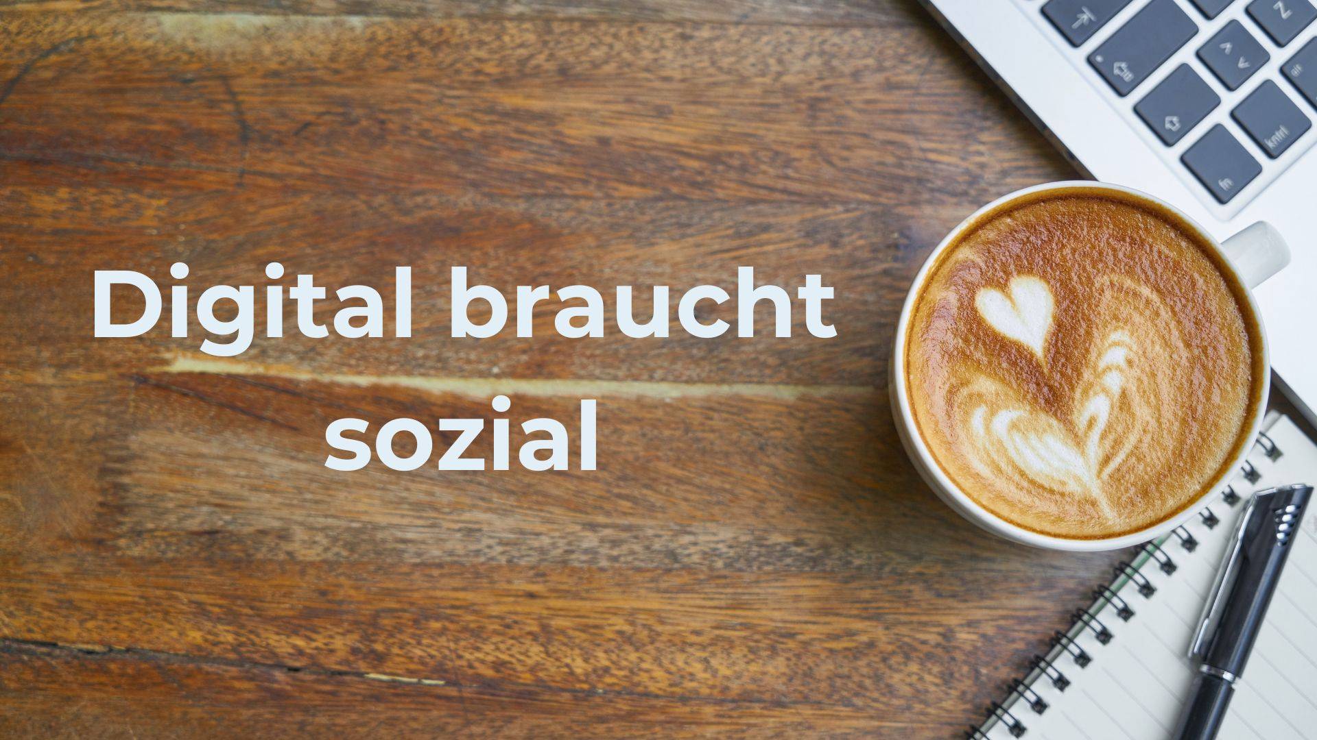 Der Schriftzug "Digital braucht sozial" in weiß vor einem holz Hintergrund. Rechts steht eine Kaffeetasse, eine Tastatur und ein Schreibblock