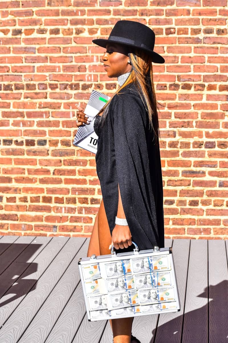 woman in black long sleeve dress holding magazine