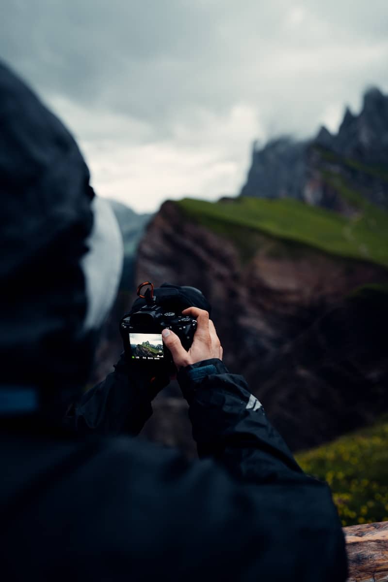 a person taking a picture of a mountain