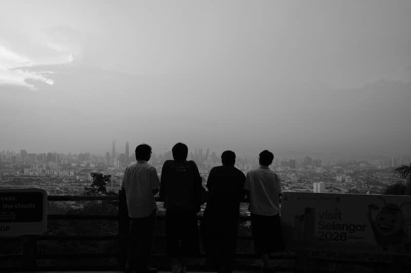 Four people look out over a hazy city skyline.