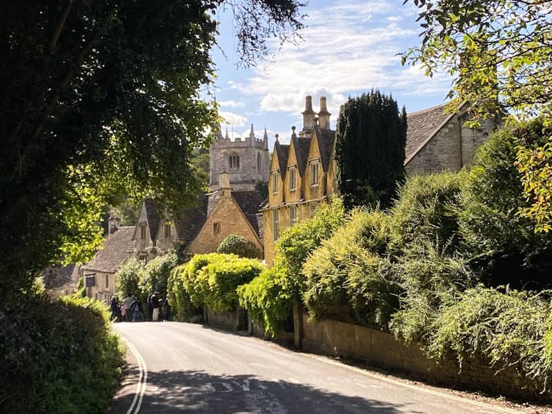 Quaint village road with historic buildings and greenery