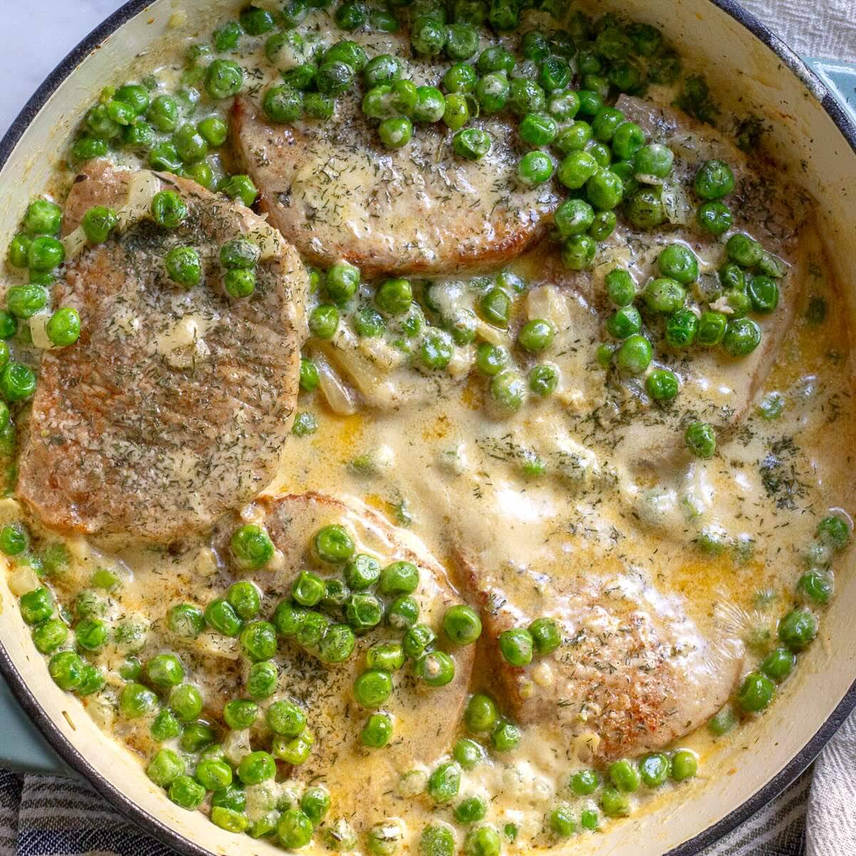 Pork Chops with Green Peas in a Creamy Sauce shown in the Skillet