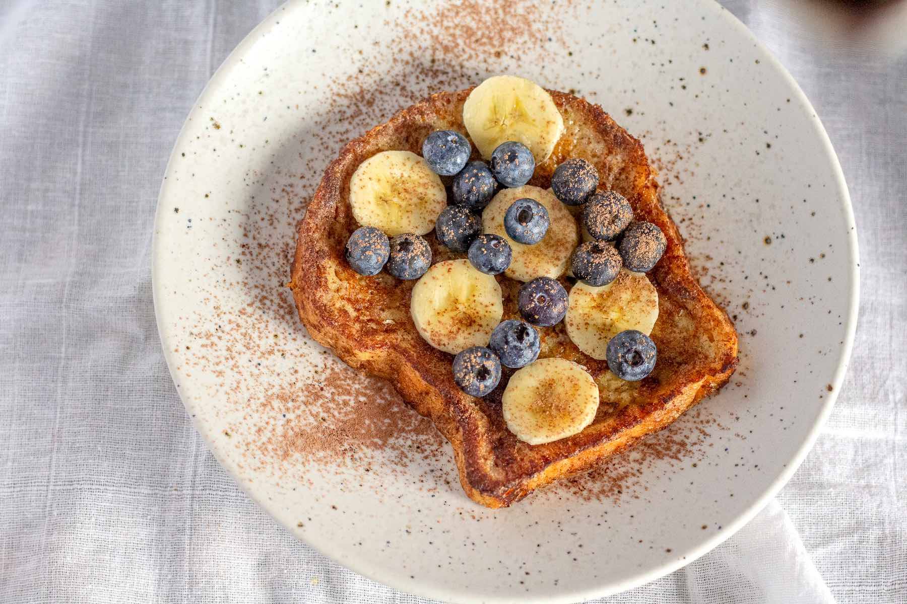 Easy French toast cooked in coconut oil and topped with fresh fruit.
