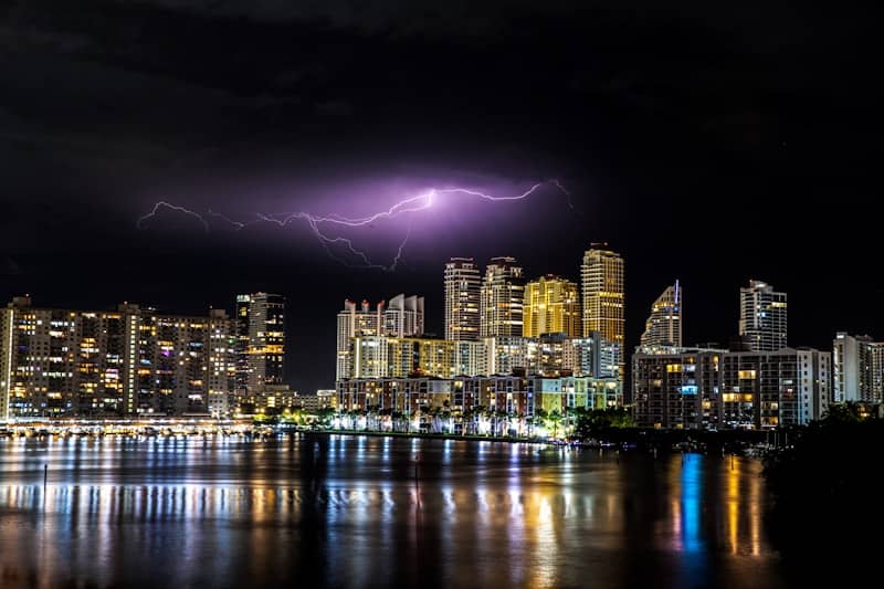 Lightning strikes over a city skyline at night