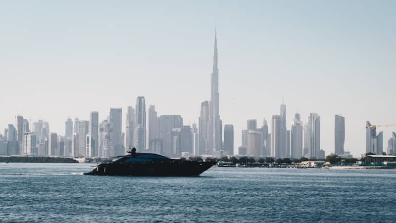 A luxury yacht sails past the dubai skyline.