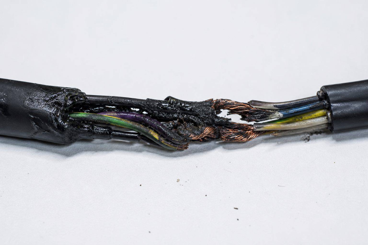 Fotografia macro forense de fios de cobre expostos e derretidos atestando o risco elétrico detectado pela Bruxel Perícias em avaliação de caminhão