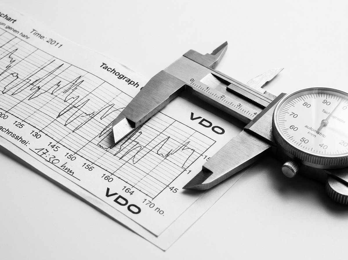 Análise de tacógrafo com paquímetro representando a precisão técnica da Bruxel Perícias no RS