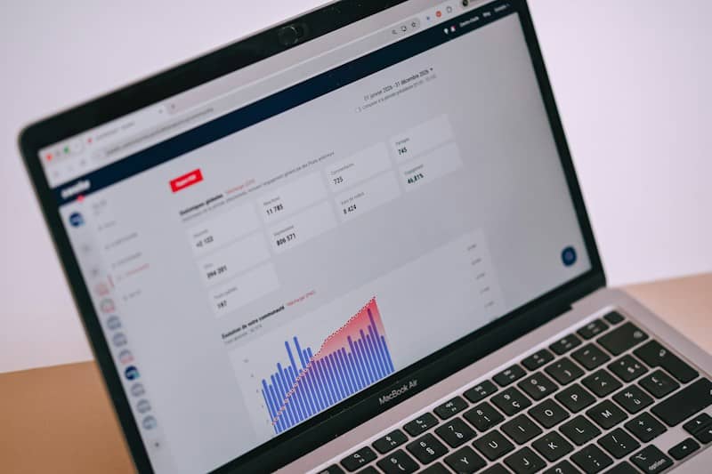 A laptop screen displays data analytics, charts, and statistics