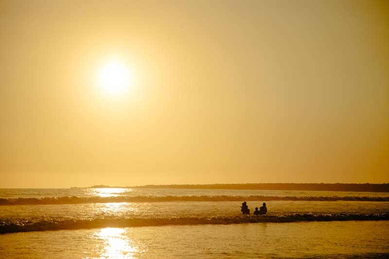 People watch the sunset over the ocean.