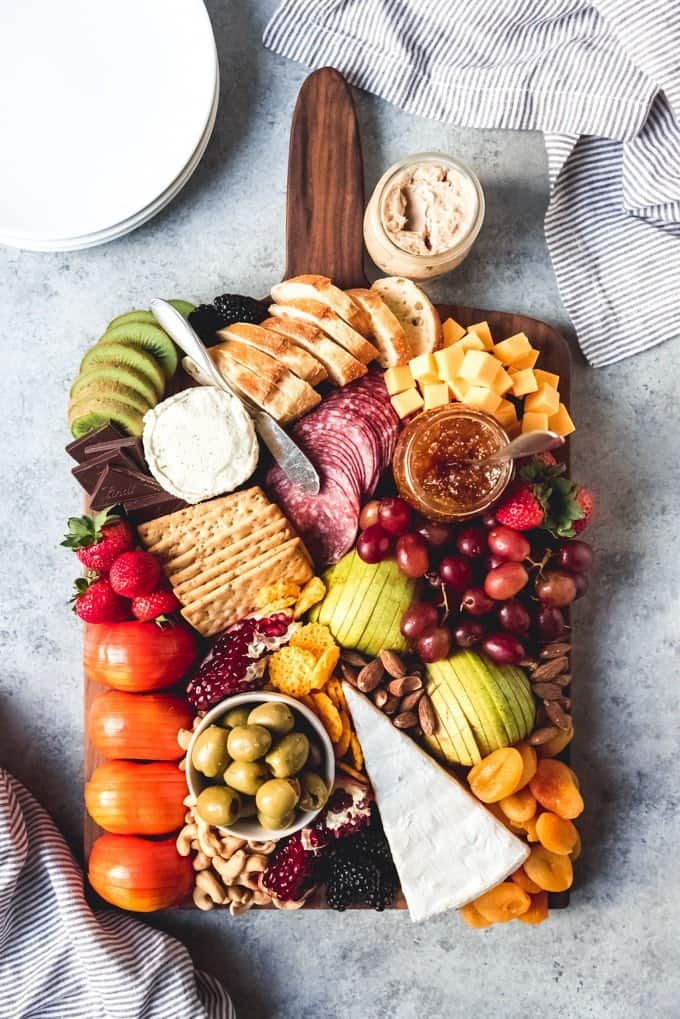 How to Make the Best Fruit and Cheese Platter - an image of a fruit and cheese platter on a wood cutting board.