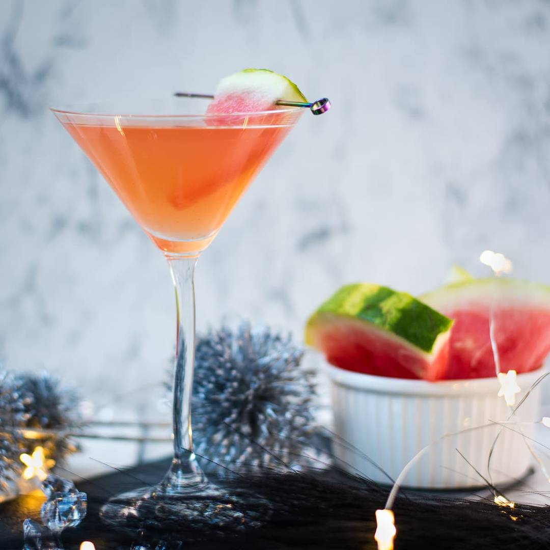Pink watermelon martini in a cocktail glass with a fresh watermelon garnish, linking to the recipe.
