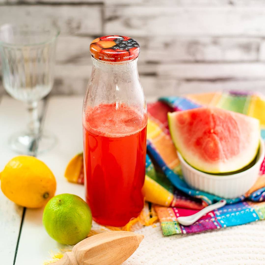 Homemade watermelon syrup in a glass bottle or jar, linking to the recipe.