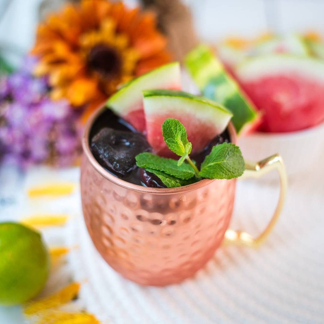 Watermelon Moscow Mule in a copper mug with fresh watermelon and mint, linking to the recipe.