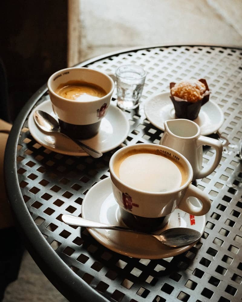 Two cups of coffee with muffin and water