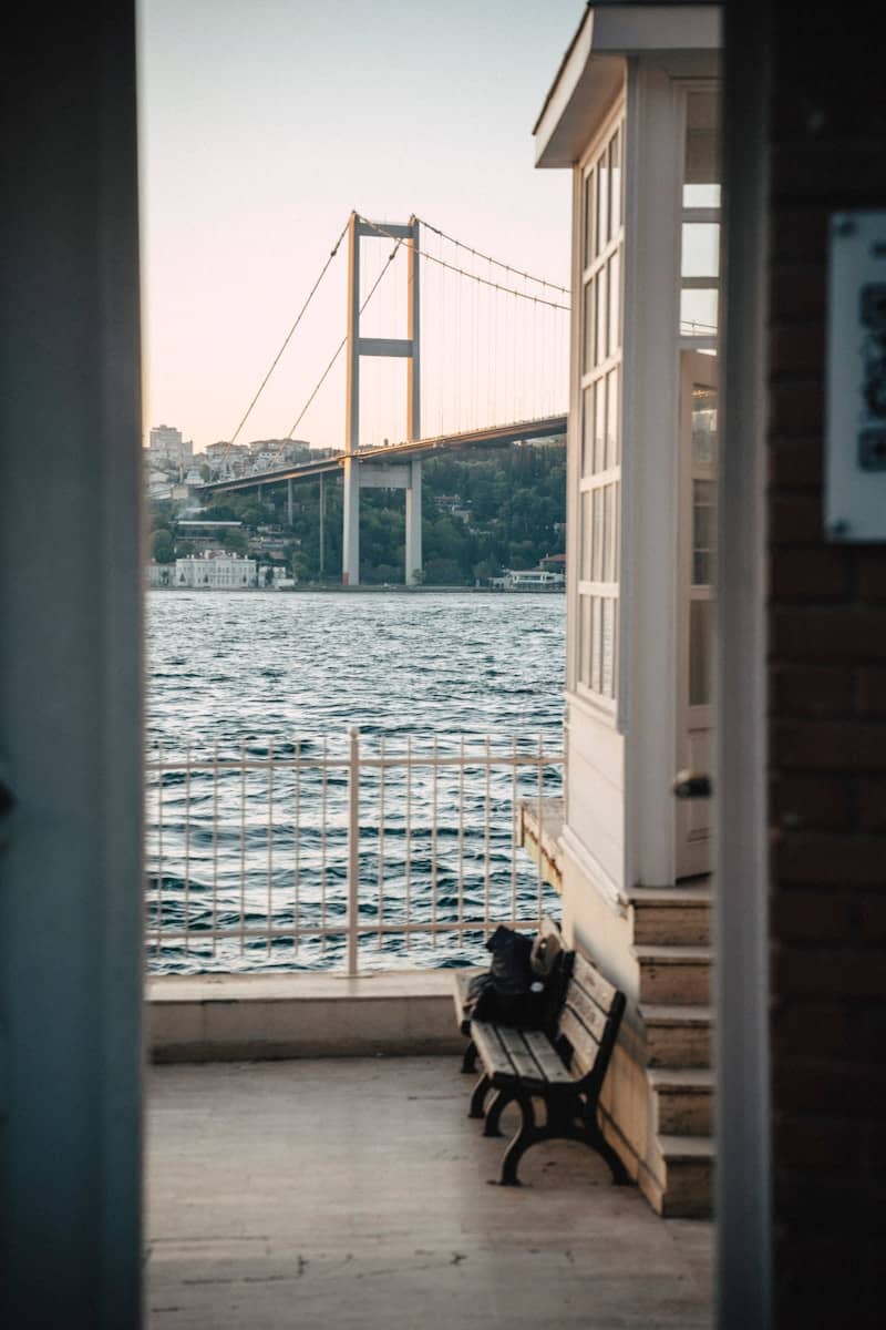 A bridge overlooks the sea and a small structure.