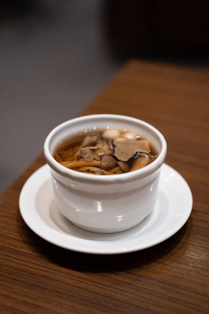 A bowl of soup on a plate on a table
