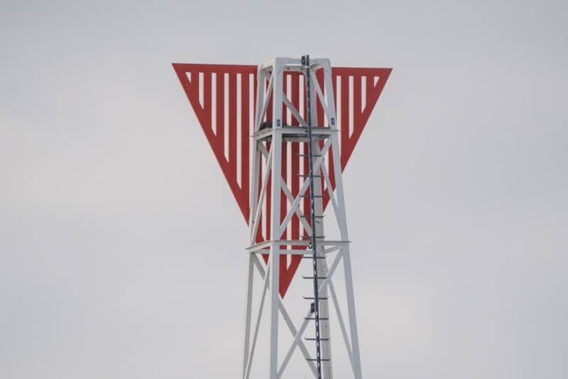 A red and white triangular structure on a tower