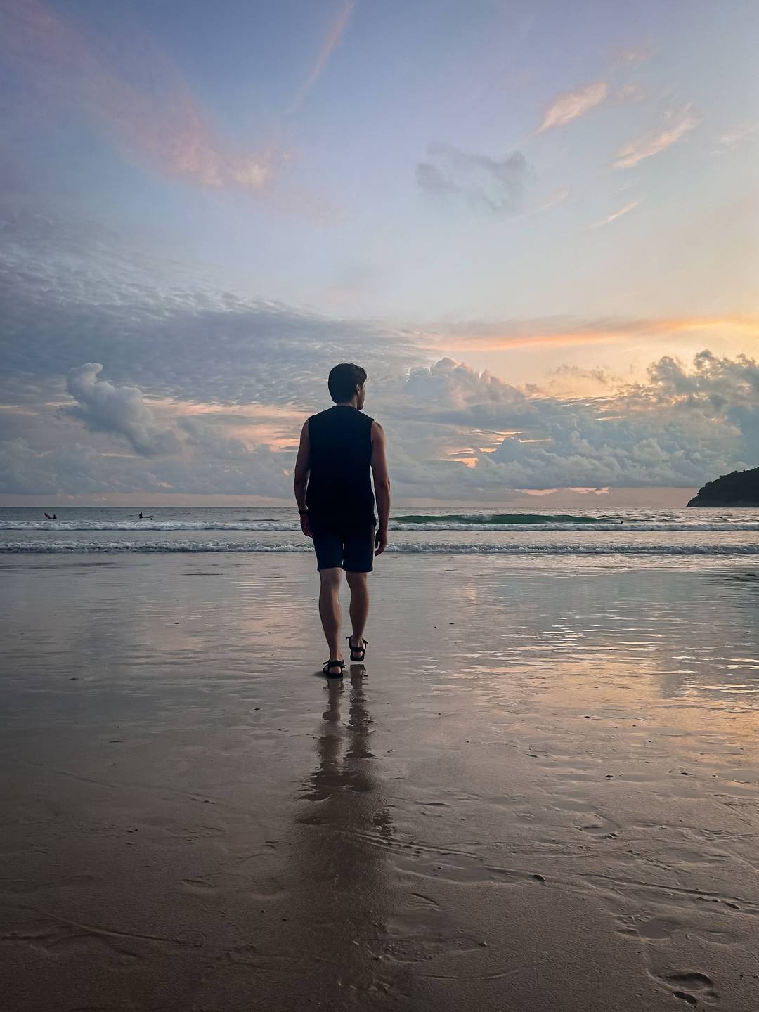 Man walking on the beach at sunset, in Thailand