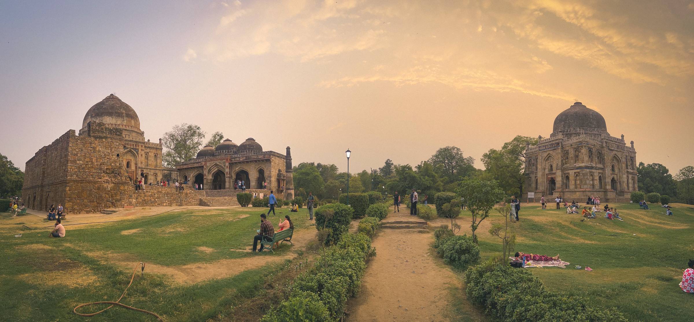 Ruins at Lodhi Park at sunset with people scattered around.
