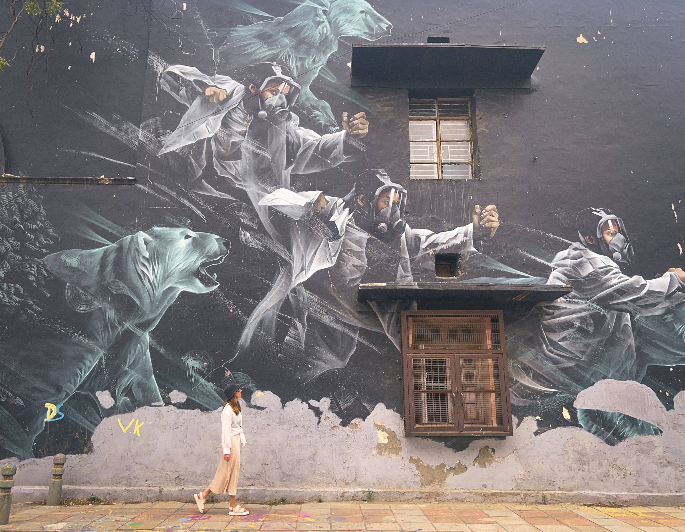 woman in front of street murals in Lodhi Colony